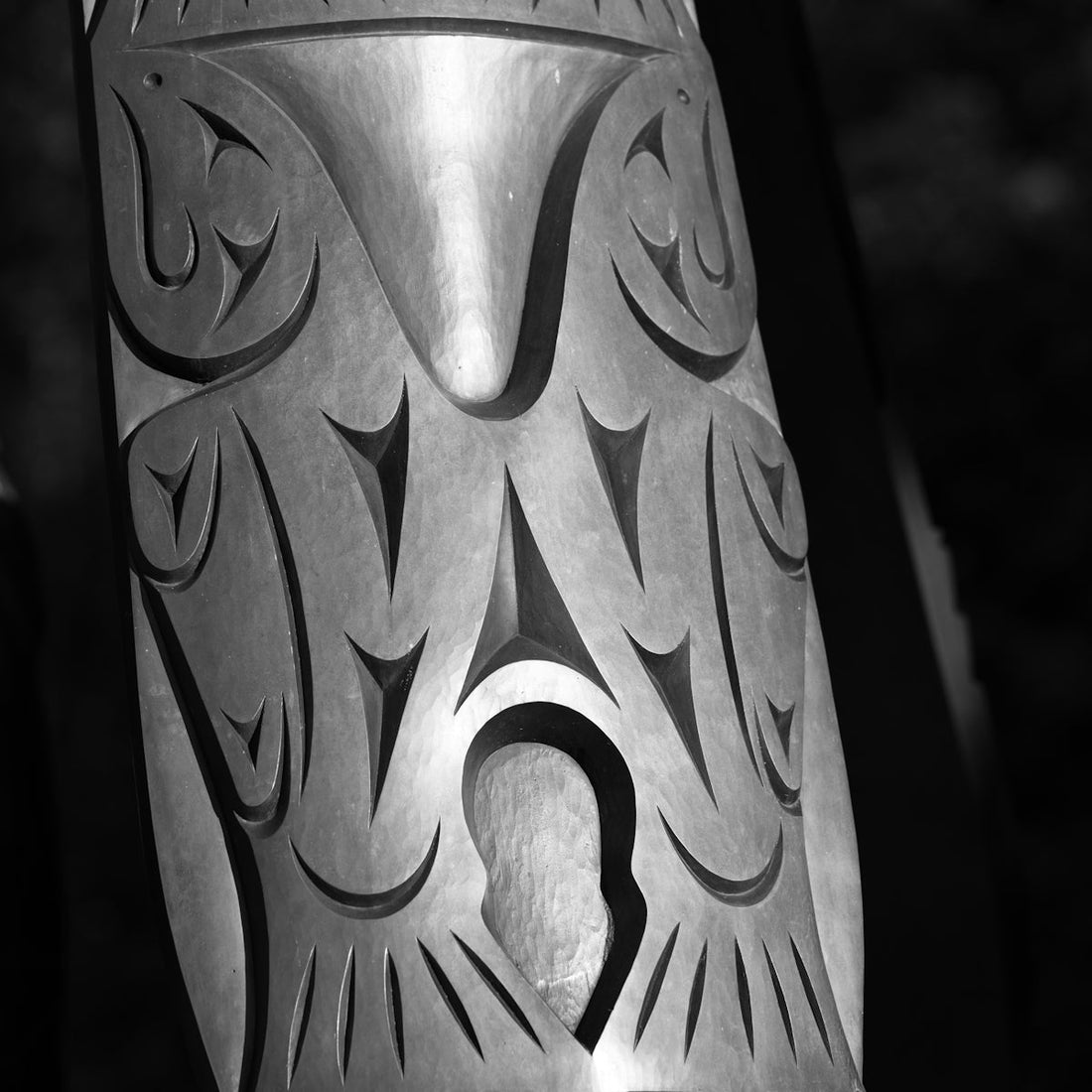 A metal vase with a design on it